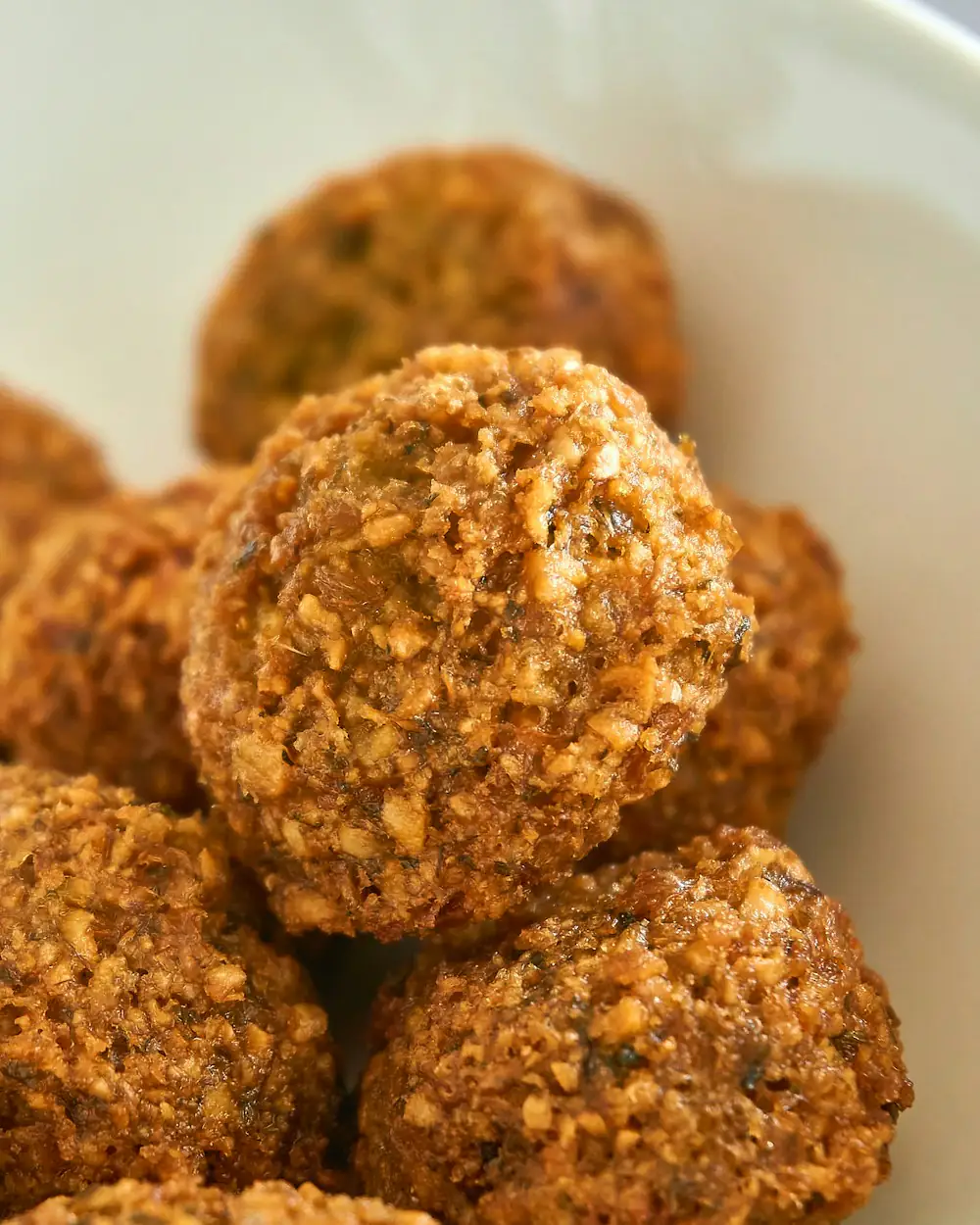 Frisch frittierte Falafelbällchen in einer weißen Schale.
