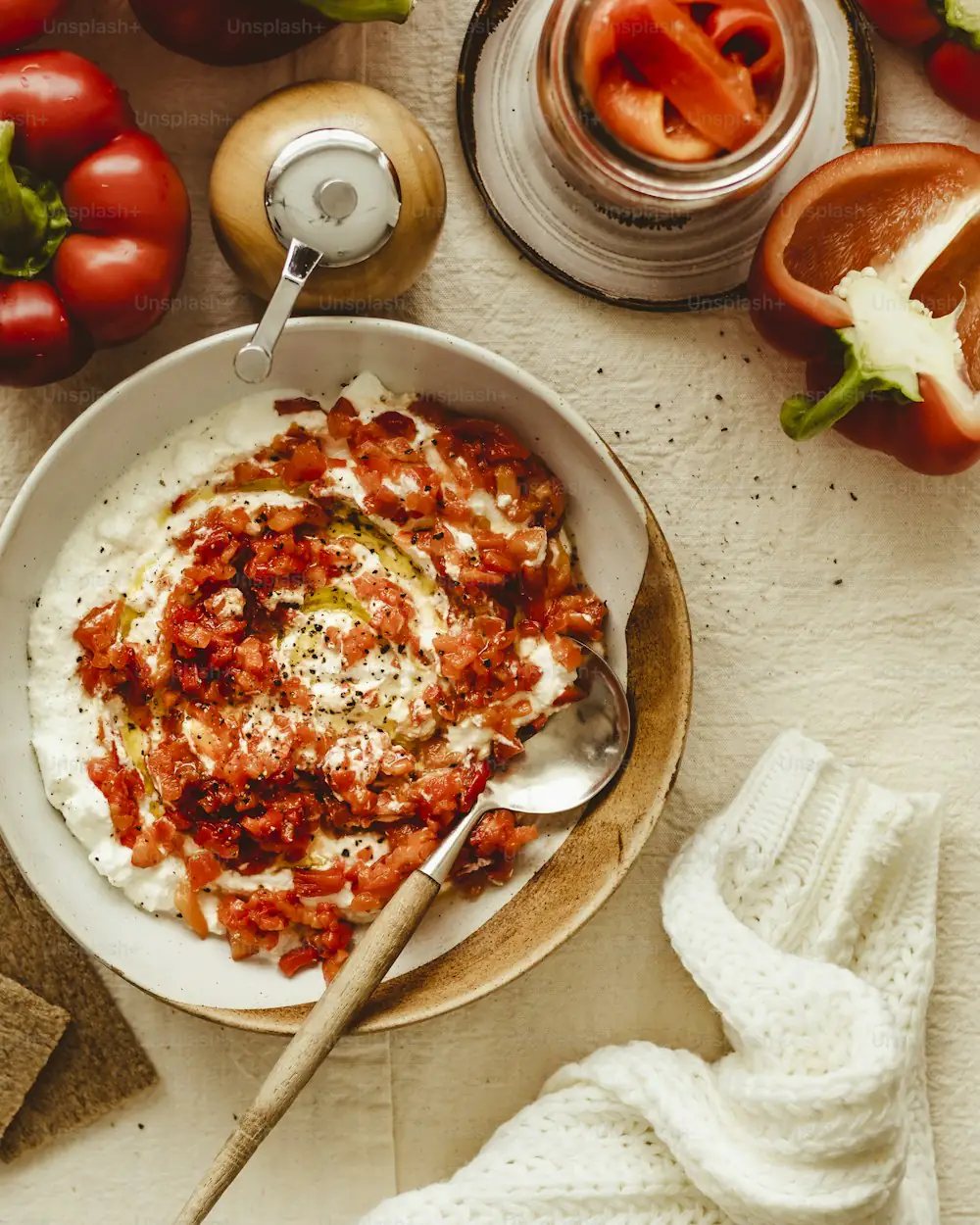 Dicker Joghurtdip in einer hellen Schale, mit rotem Gewürzöl und Kräutern.